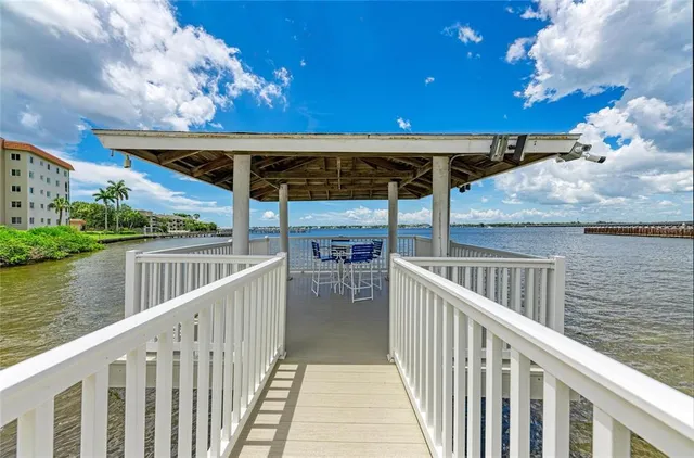 a kitchen with a sink a refrigerator a stove top oven a dining table and chairs