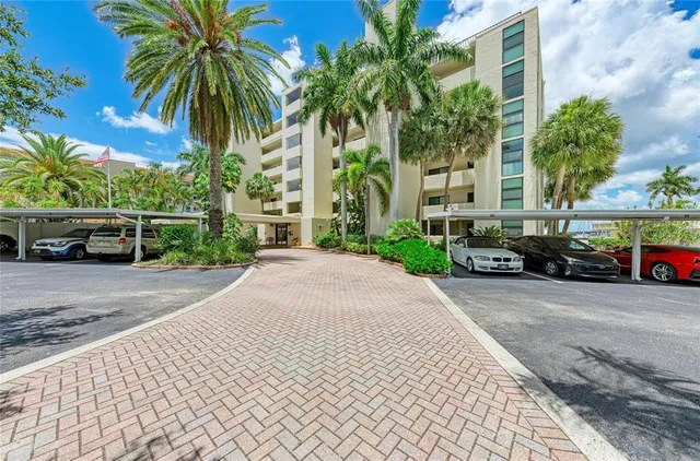 a view of a car parked in front of a building with palm trees