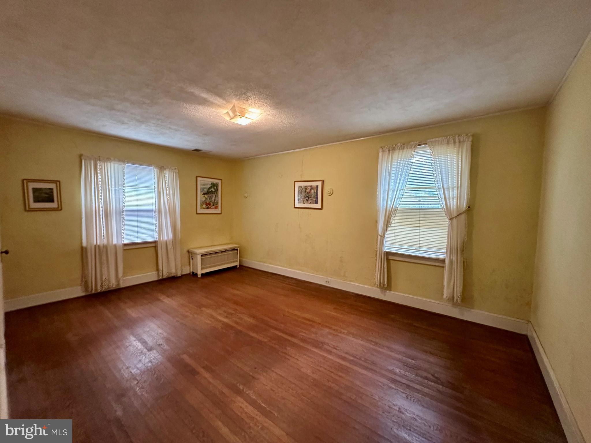 112 Elmhurst Road Baltimore, MD 21210 - Photo 14 of 29 a view of empty room with wooden floor and fan