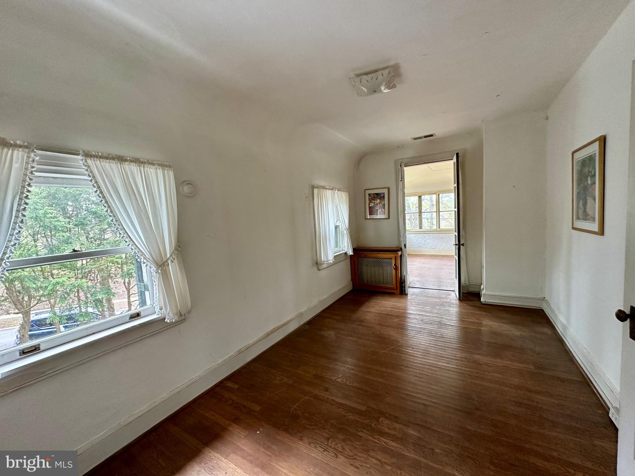 112 Elmhurst Road Baltimore, MD 21210 - Photo 23 of 29 a view of an empty room with wooden floor and a window
