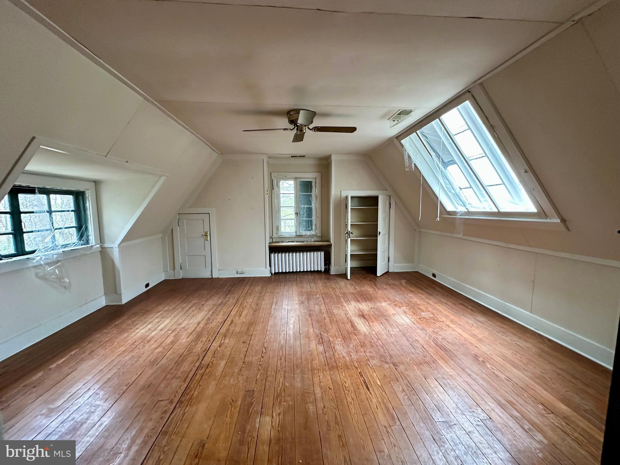 112 Elmhurst Road Baltimore, MD 21210 - Photo 25 of 29 an empty room with wooden floor chandelier and windows