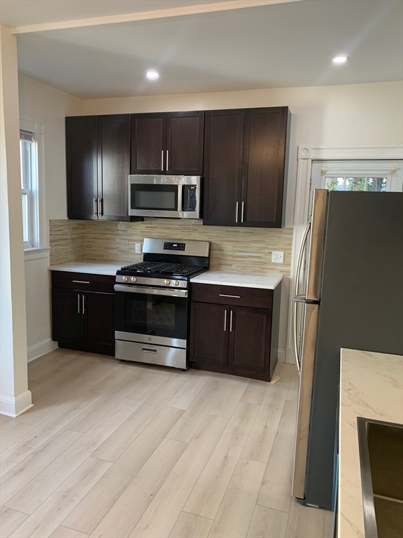 9 Kerwin Street, Unit 2 Boston, MA 02124 - Photo 3 of 13 a kitchen with stainless steel appliances a stove a sink and a refrigerator
