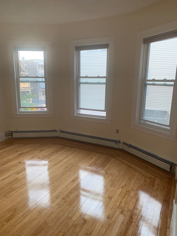 9 Kerwin Street, Unit 2 Boston, MA 02124 - Photo 4 of 13 an empty room with wooden floor and windows