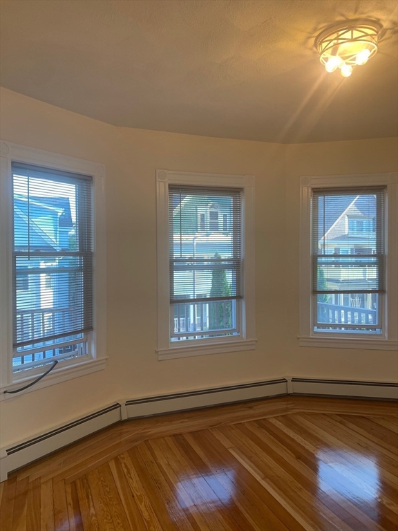 9 Kerwin Street, Unit 2 Boston, MA 02124 - Photo 5 of 13 a view of an empty room with wooden floor and fan