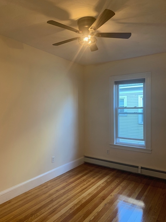 9 Kerwin Street, Unit 2 Boston, MA 02124 - Photo 7 of 13 an empty room with wooden floor fan and windows