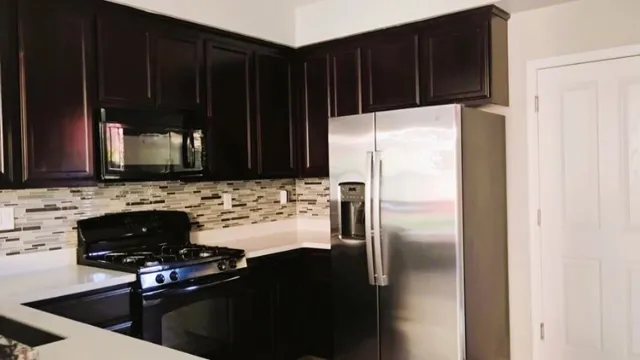 a kitchen with a refrigerator and a stove top oven