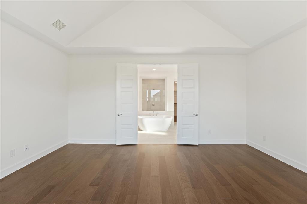 4626 Rillstone Road Midlothian, TX 76065 - Photo 14 of 40 Unfurnished bedroom featuring dark wood-style floors, high vaulted ceiling, and ensuite bath