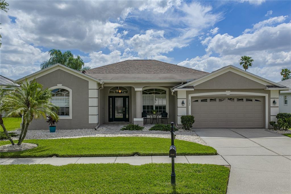 1542 Swamp Rose Lane Trinity, FL 34655 - Photo 15 of 64 a front view of a house with garden