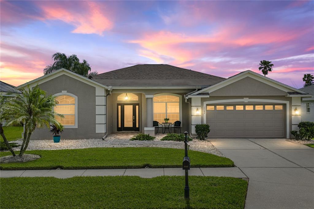 1542 Swamp Rose Lane Trinity, FL 34655 - Photo 2 of 64 a front view of a house with a garden and yard