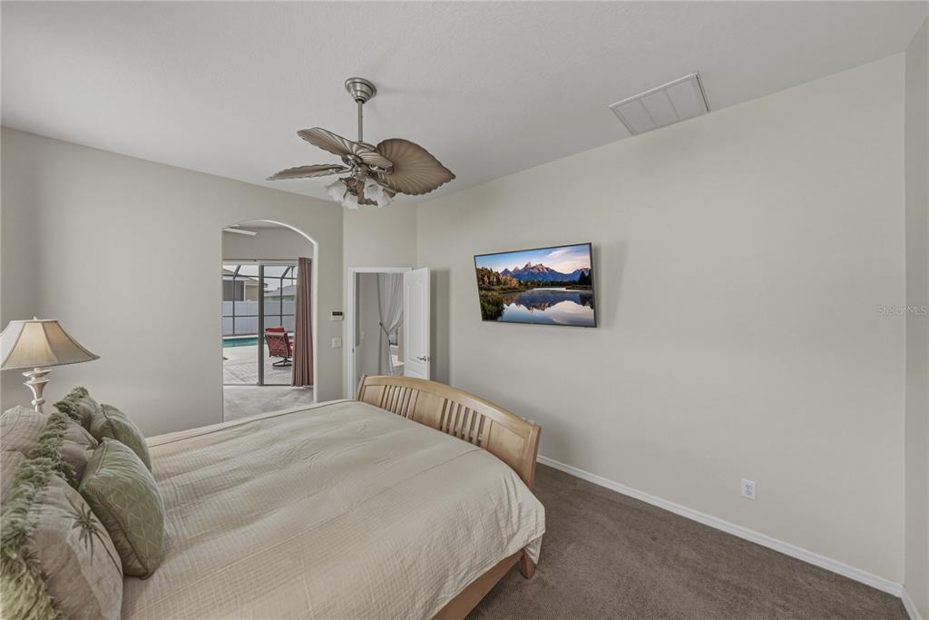 1542 Swamp Rose Lane Trinity, FL 34655 - Photo 36 of 64 a bedroom with a bed and a chandelier