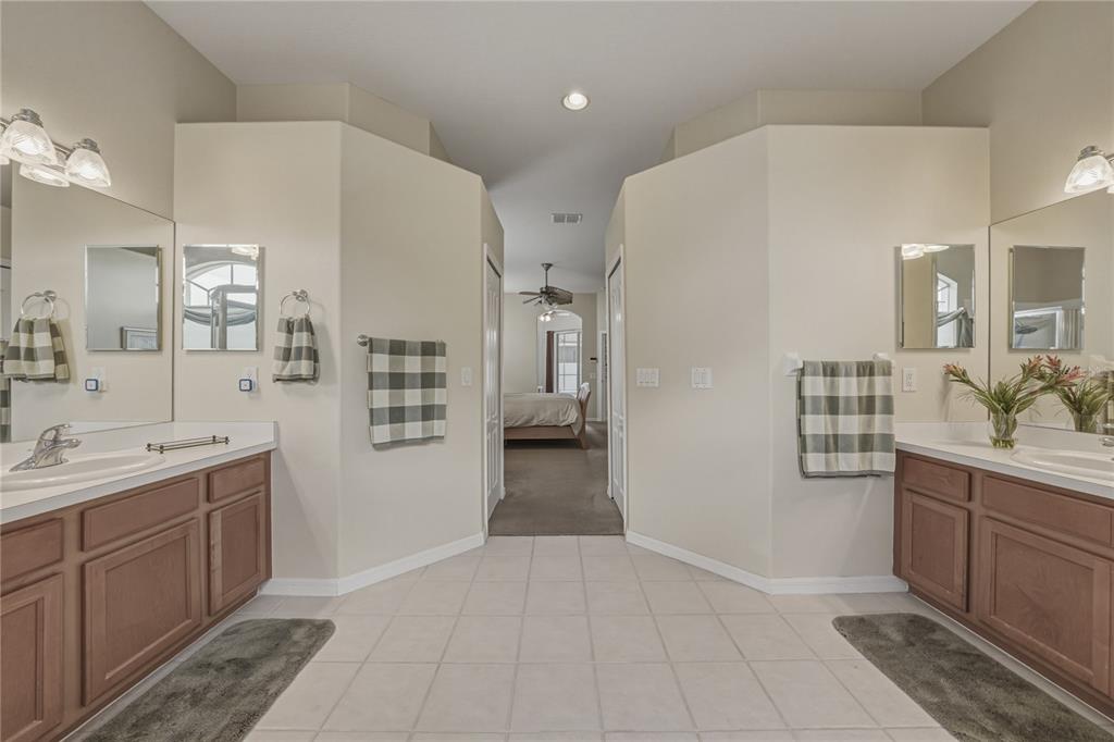 1542 Swamp Rose Lane Trinity, FL 34655 - Photo 43 of 64 a spacious bathroom with a granite countertop sink a toilet a mirror and vanity