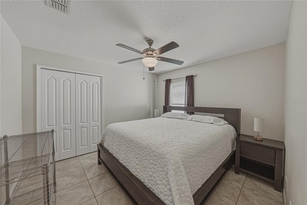 1542 Swamp Rose Lane Trinity, FL 34655 - Photo 44 of 64 a bedroom with a bed and a ceiling fan