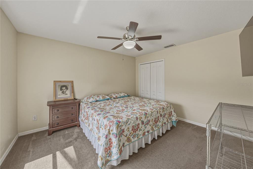 1542 Swamp Rose Lane Trinity, FL 34655 - Photo 51 of 64 a bedroom with a bed and a ceiling fan