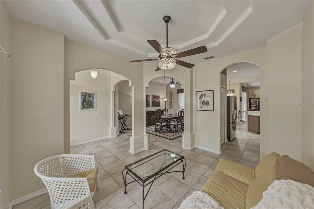1542 Swamp Rose Lane Trinity, FL 34655 - Photo 7 of 64 a living room with furniture a chandelier and a rug
