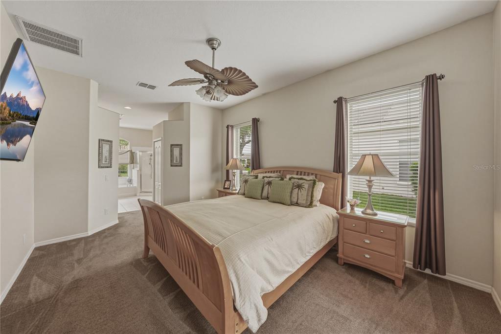 1542 Swamp Rose Lane Trinity, FL 34655 - Photo 10 of 64 a bedroom with a bed and a chandelier