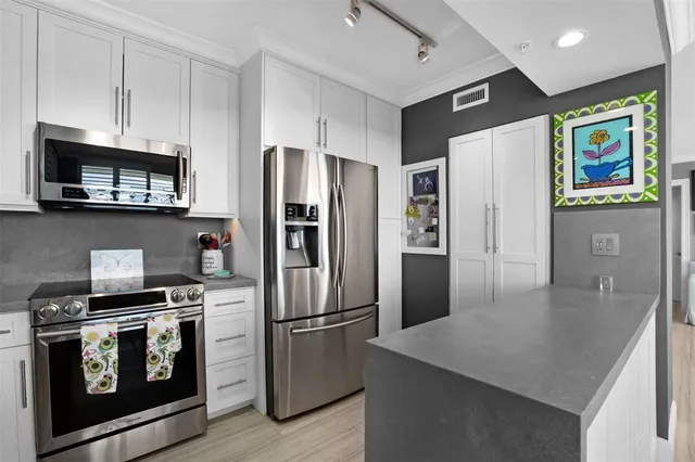a kitchen with stainless steel appliances granite countertop a refrigerator stove and microwave