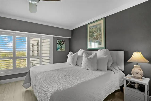 a bedroom with a bed and a large window