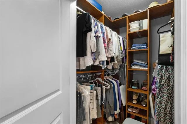 a view of walk in closet with clothes and shoes