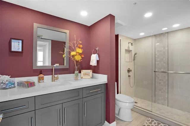 a bathroom with a sink a toilet a large mirror and shower