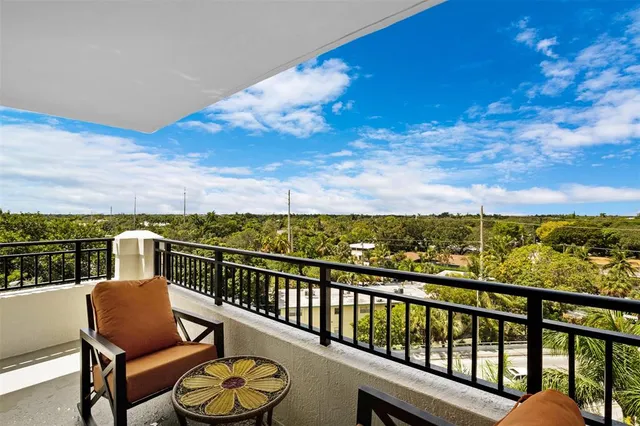 a view of a city from a balcony with chairs