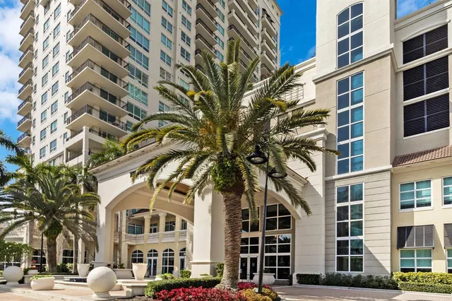 a large white bedroom with a bed and a chandelier