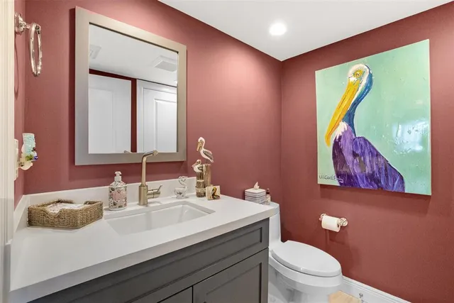 a bathroom with a toilet a sink and mirror