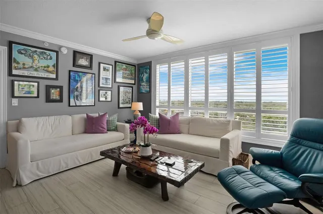 a living room with furniture and floor to ceiling windows