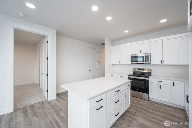 a kitchen with white cabinets and white appliances