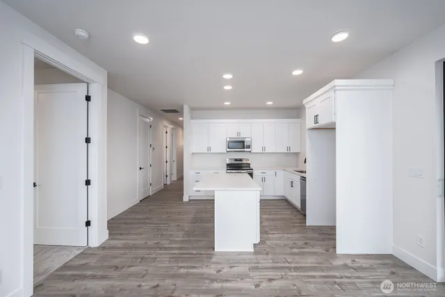 a large white kitchen with white cabinets and a stainless steel appliances