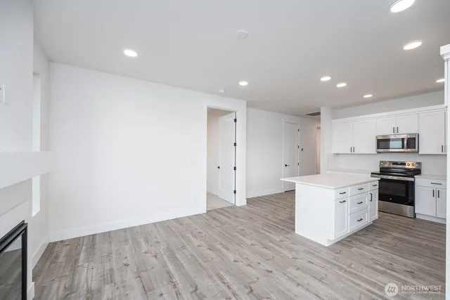 a large kitchen with stainless steel appliances granite countertop a large counter top and a stove top oven