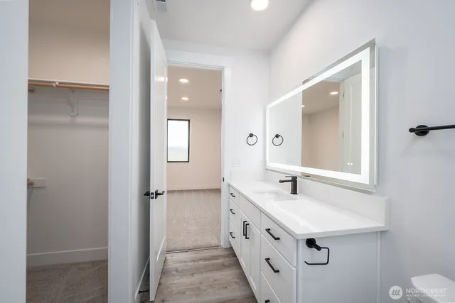 a bathroom with a double vanity sink mirror and toilet