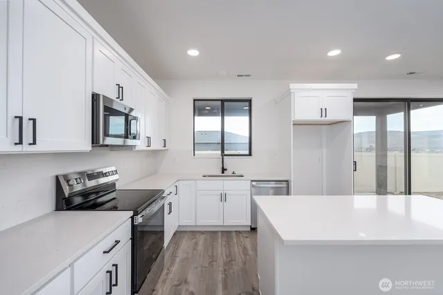 a kitchen with a sink a stove and cabinets