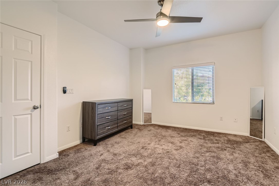 7701 West Robindale Road, Unit 265 Las Vegas, NV 89113 - Photo 14 of 27 Plush carpeting and generous natural light define this versatile secondary bedroom space.