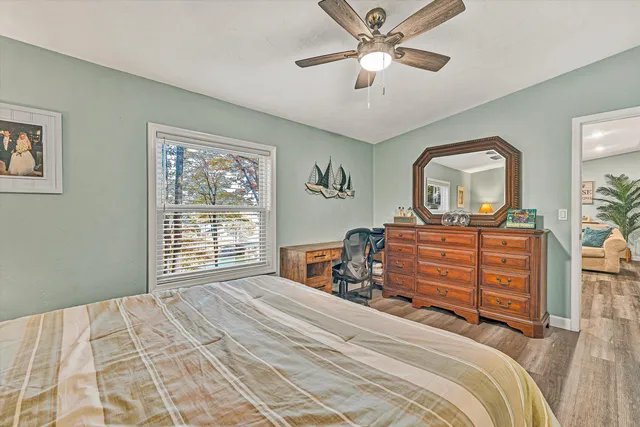 a bedroom with a bed a dresser and chair