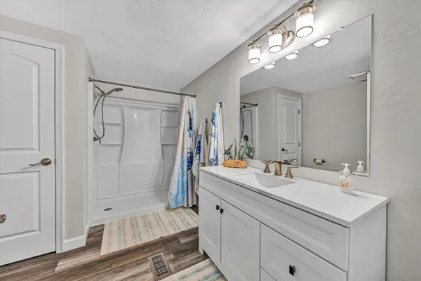a bathroom with a double vanity sink mirror and shower