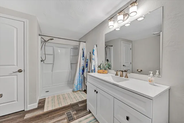 a bathroom with a double vanity sink mirror and shower