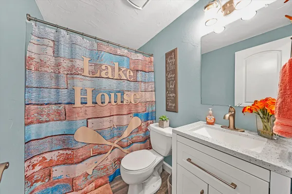 a bathroom with a sink mirror vanity and toilet