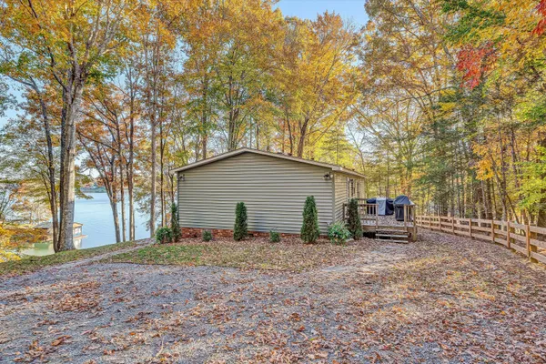 a backyard of a house with lawn chairs and a large tree