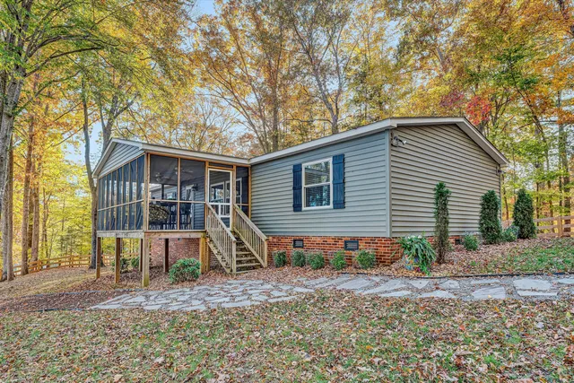 a view of a house with a yard and large trees