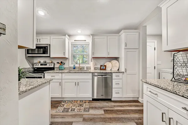 a kitchen with stainless steel appliances granite countertop a stove a sink and a refrigerator