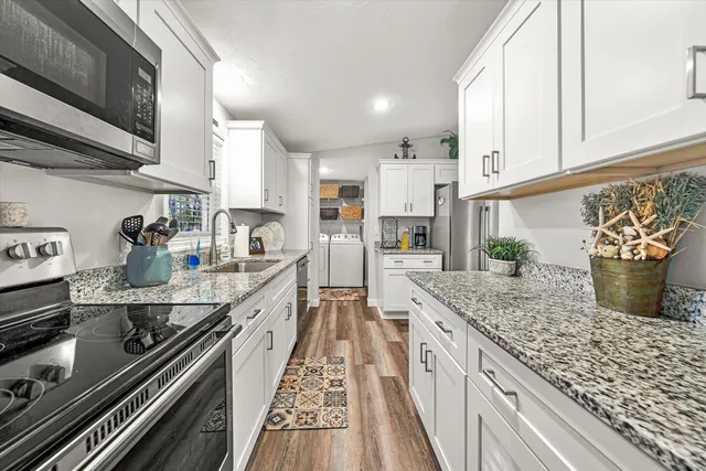 a kitchen with stainless steel appliances granite countertop a lot of counter space and wooden floor