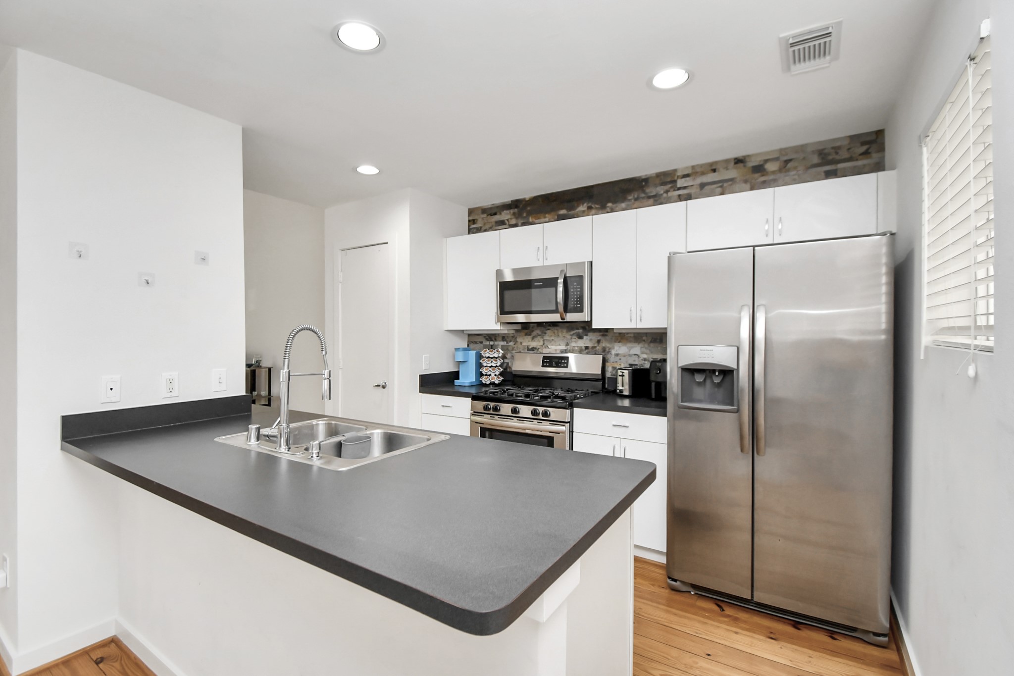 1806 Drew Street Houston, TX 77004 - Photo 6 of 17 a kitchen with kitchen island a sink refrigerator and microwave