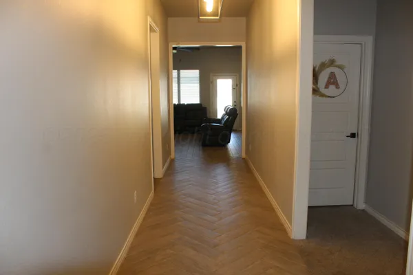a view of a hallway with a livingroom and a bathroom