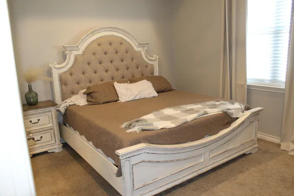 a bed sitting in a bedroom next to a window