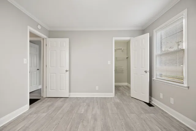 an empty room with wooden floor and windows