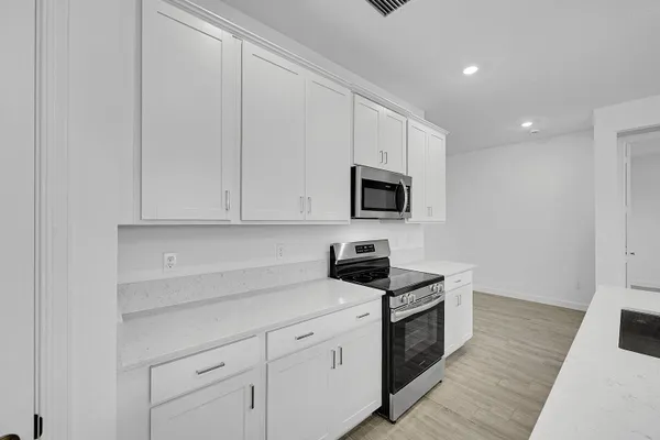 a kitchen with white cabinets stainless steel appliances and sink