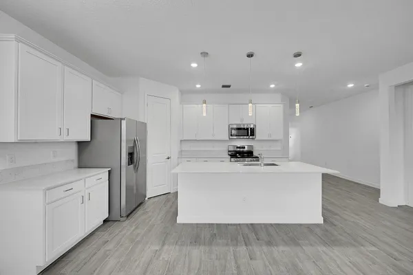 a view of kitchen with stainless steel appliances refrigerator stove microwave and cabinets