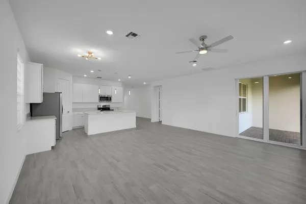 a view of an empty room with kitchen appliances and a kitchen view