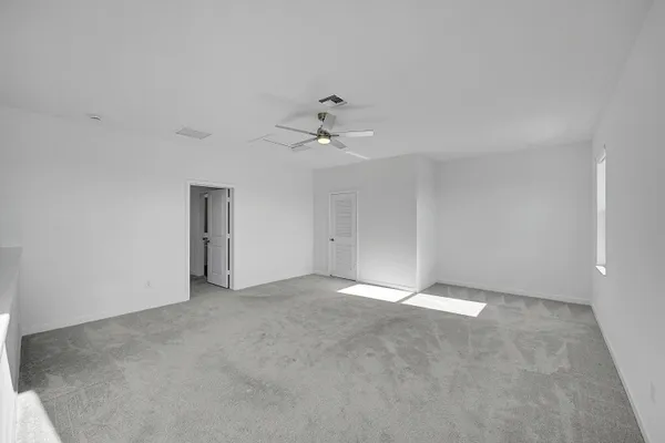 an empty room with fan and windows