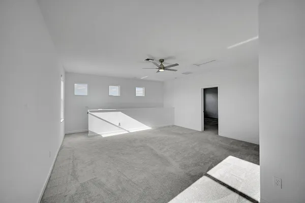 an empty room with a ceiling fan and a window